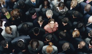 Businesswoman Looking up Surrounded by a Large Group of Business People